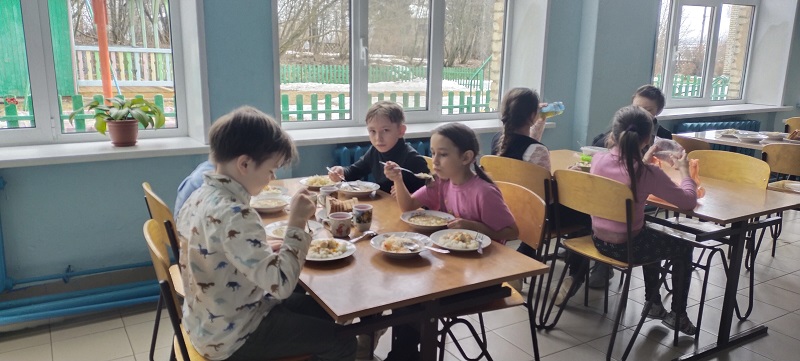 дети принимают пищу в столовой школы